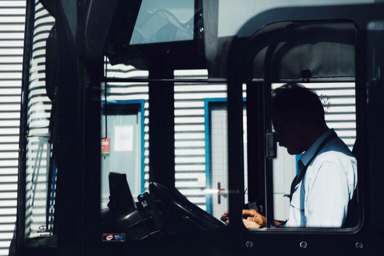 Kierowca autobusu na postoju, skupiony na planowaniu pracy.