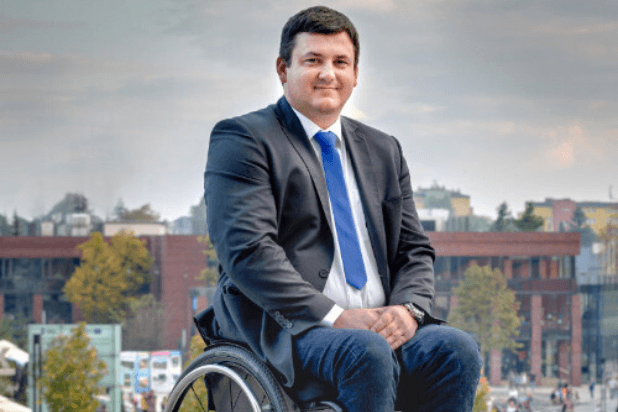 Piotr Czarnota siedzący na wózku na tle miasta